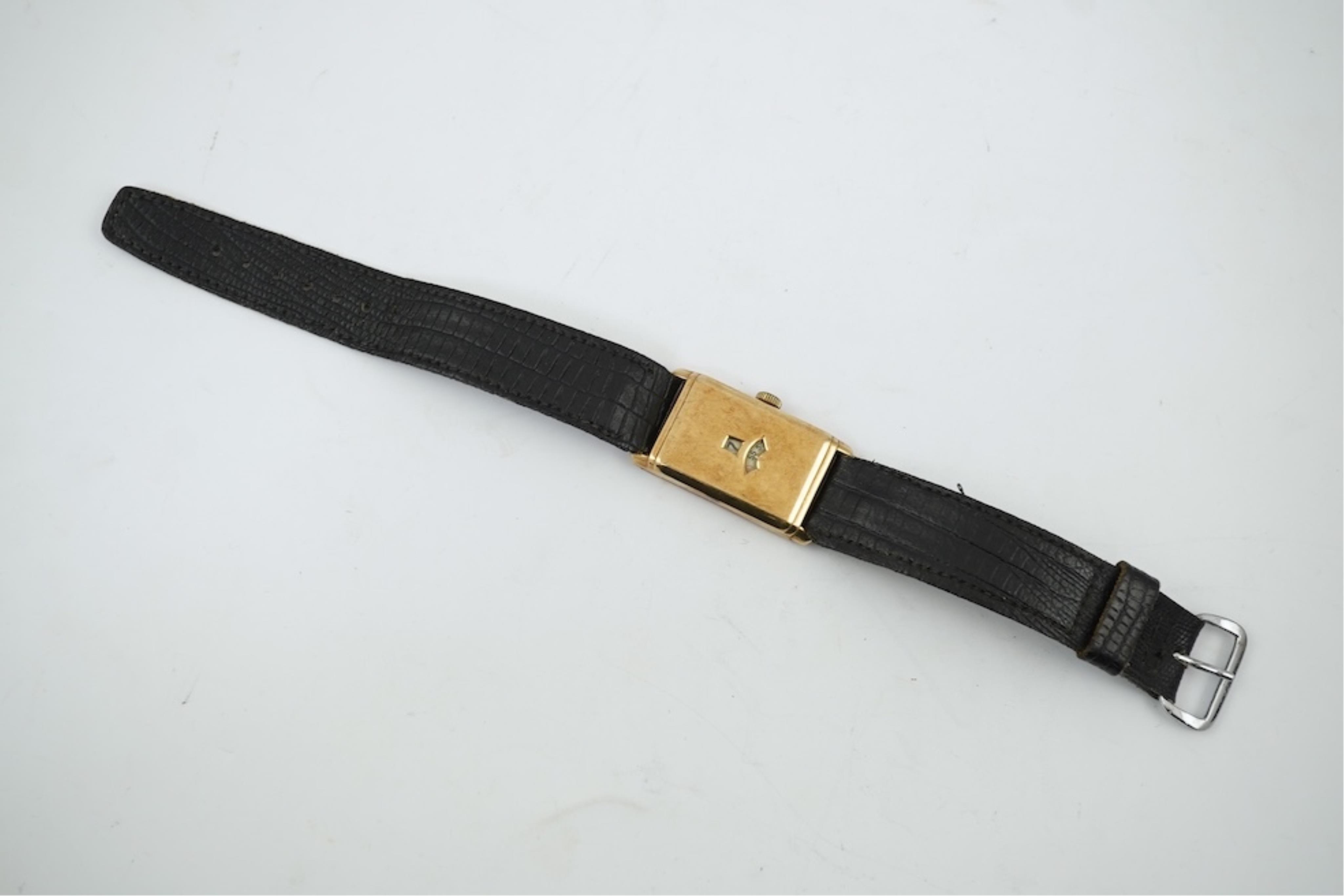 An early 1930's 9ct gold Swiss 'Jump Hour' rectangular cased manual wind wrist watch, case diameter 20mm, on a leather strap, gross weight 23 grams.